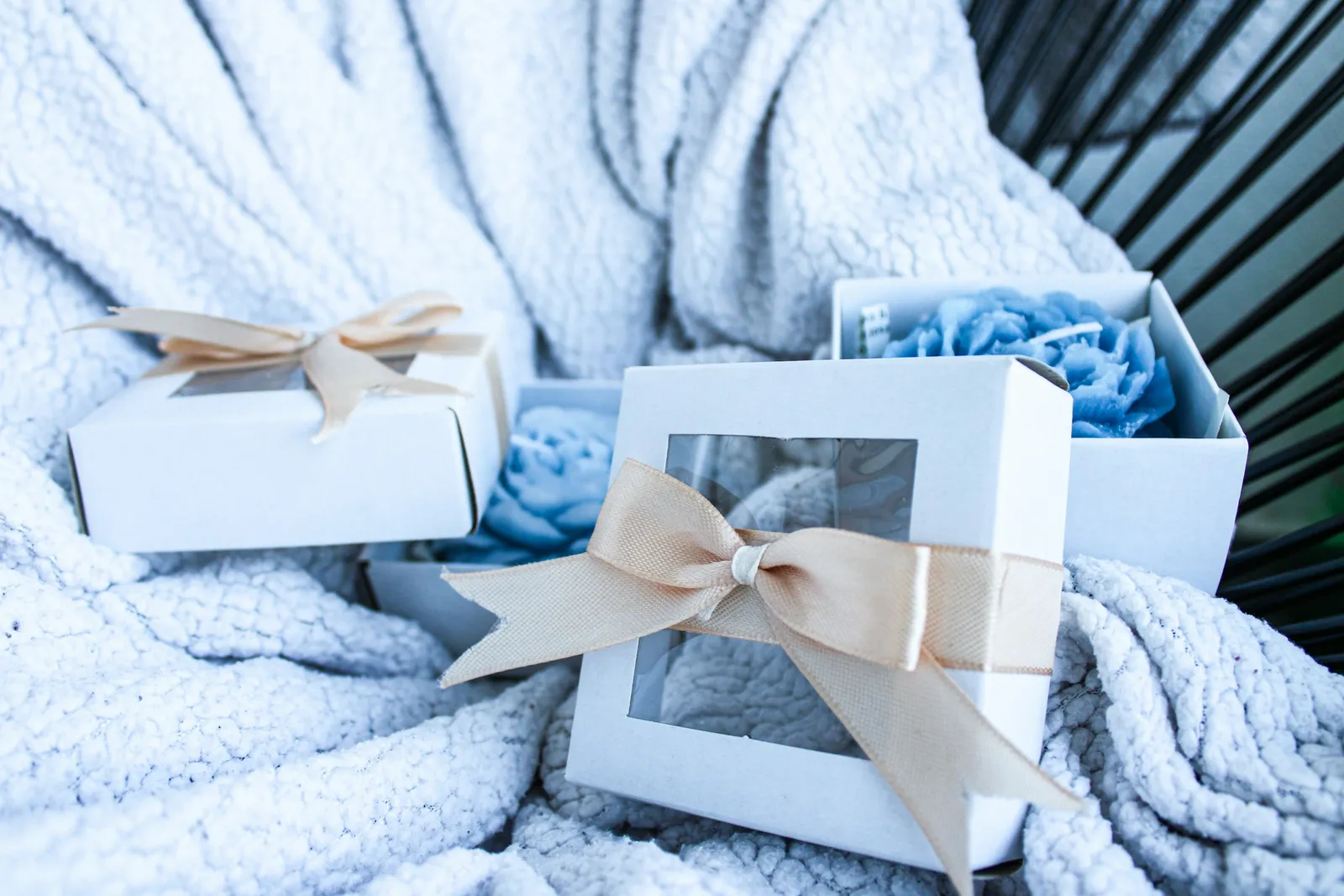 Boîtes cadeaux nouées d'un ruban posées sur un plaid moelleux
